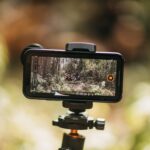 Smartphone mounted on tripod capturing nature. Ideal for vlogging and travel videos.