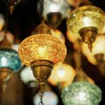 Bright and ornate Turkish lanterns illuminated indoors, showcasing vibrant colors and traditional design.