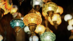 Bright and ornate Turkish lanterns illuminated indoors, showcasing vibrant colors and traditional design.