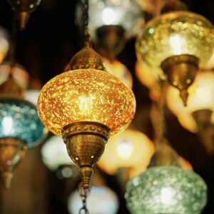 Bright and ornate Turkish lanterns illuminated indoors, showcasing vibrant colors and traditional design.